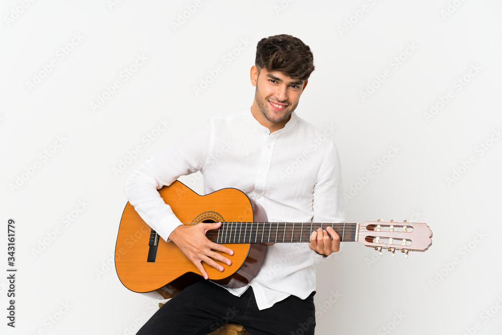 Obraz premium Young handsome man with guitar over isolated white background