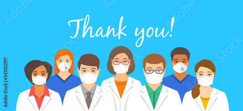 Doctors team in protective face masks with thank you inscription. Appreciation for hospital staff fighting the spread of coronavirus. Personnel of medical clinic, physicians and nurses stand together