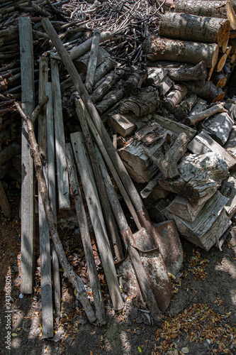 Fototapeta Naklejka Na Ścianę i Meble -  Stack of firewood. Mess of old shovels, woods and dirty tree branches. Rustic textures