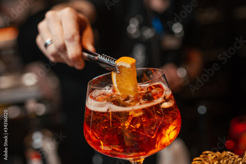 Obraz na płótnie The bartender is preparing an Aperol Spritz cocktail. Close-up w salonie