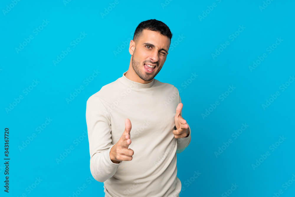 Young man over isolated blue background pointing to the front and smiling Young man over isolated blue background pointing to the front and smiling