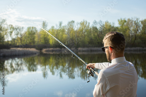 A man fishing in a business suit, in a white shirt and tie