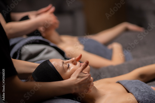 young and beautiful woman lie on massage desk  relax and enjoy  get healthy treatment of skin  in luxury wellness center