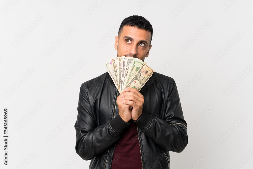 Young man over isolated white background taking a lot of money Young man over isolated white background taking a lot of money