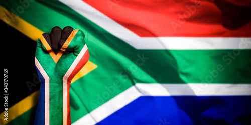 Bild auf Leinwand Banner of Flag of South Africa painted on male fist, fist flag, country of South Africa, strength, power, concept of conflict