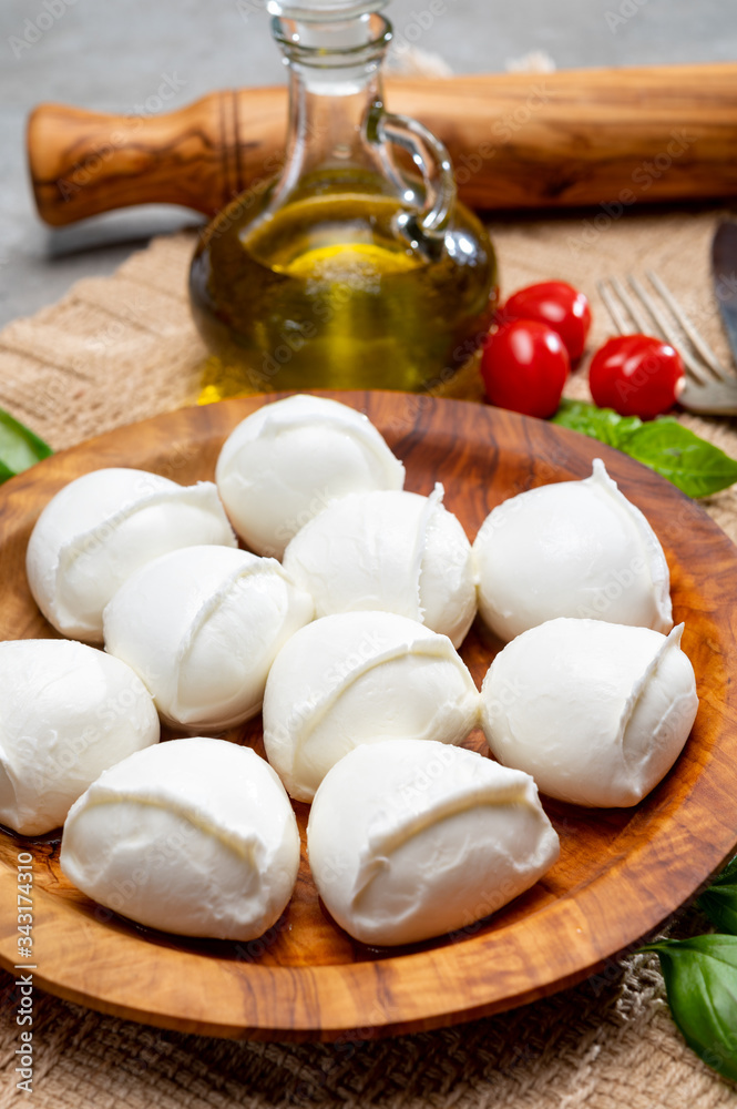 Tasty italian food, fresh white buffalo mozzarella soft cheese balls from Campania, tomatoes, fresh basil and olive oil Tasty italian food, fresh white buffalo mozzarella soft cheese balls from Campania, tomatoes, fresh basil and olive oil