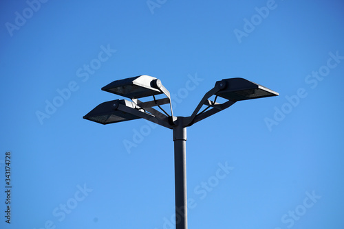 Modern street lamps against a blue sky