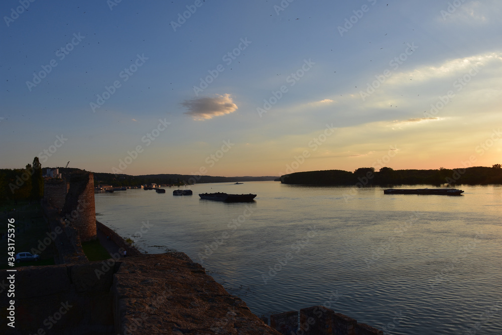 Landscape of the Danube River. Bright yellow sky over the Danube after sunset