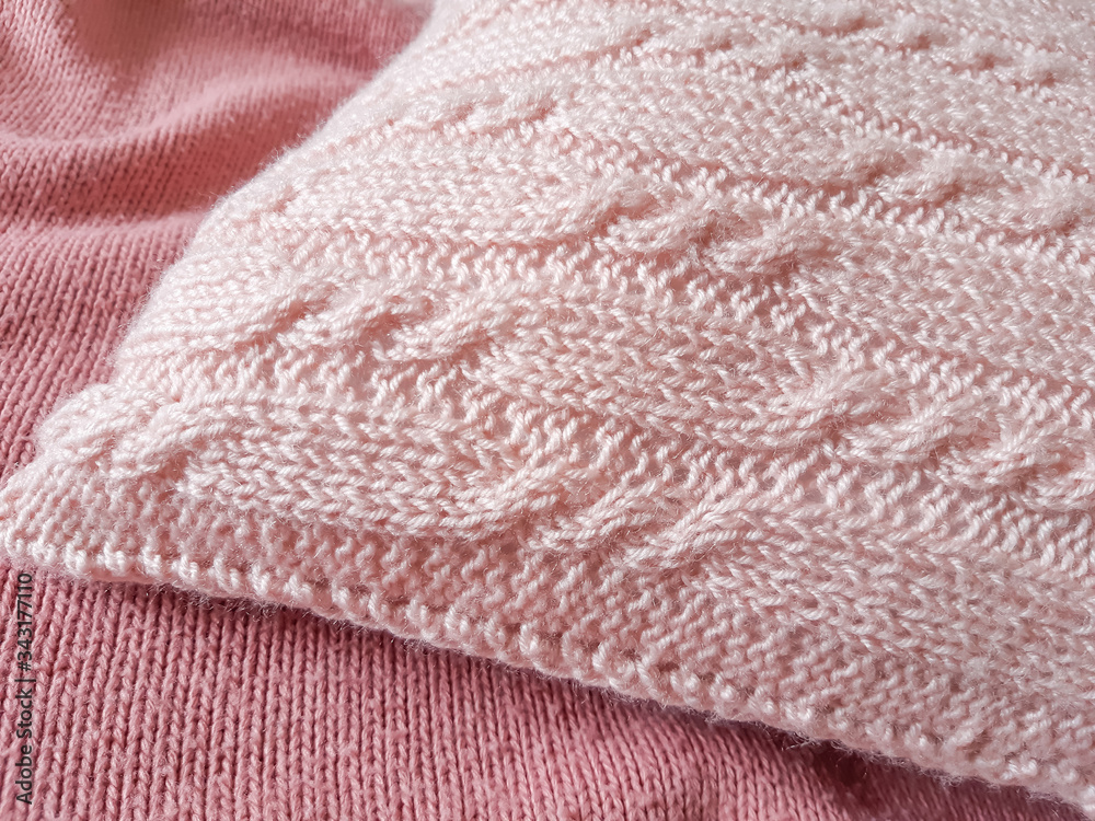Handmade knitted cushion, soft pink pillow with cables knit stitches design on bed cover. Home decor elements Handmade knitted cushion, soft pink pillow with cables knit stitches design on bed cover. Home decor elements