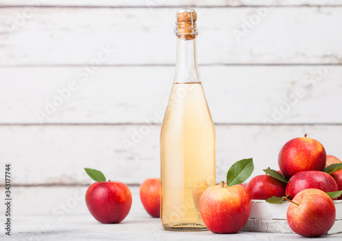 Bottle of homemade organic apple cider with fresh apples in box on wooden background. Space for text