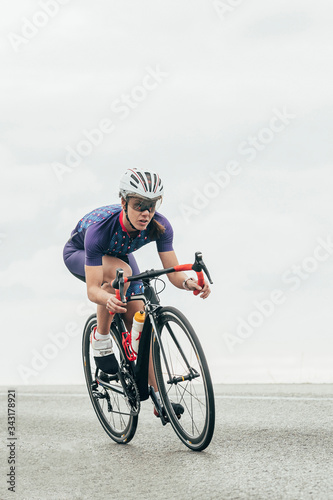 Isolated female road cyclist cycling fast