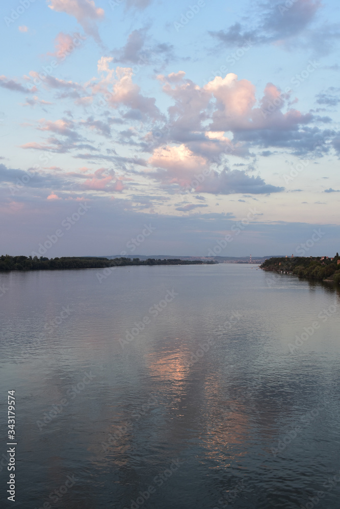 Fototapeta premium Colorful sky above the broad water of the Danube