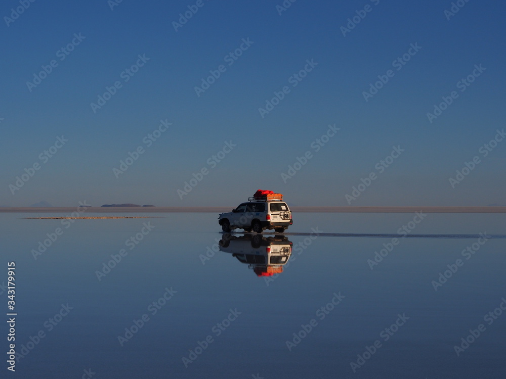 Fototapeta premium Car in the world's largest salt flat, Uyuni Salt Flat, Salar de Uyuni, Bolivia. Copy space for text