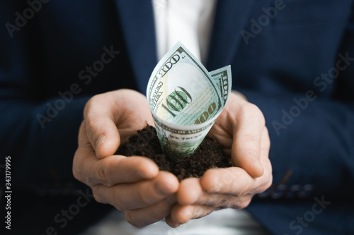 100 dollars growing money in businessman hands. Investment And Interest Concept. businessman protects growing investments.
