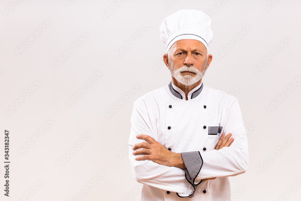 Portrait of angry senior chef on gray background. Portrait of angry senior chef on gray background.