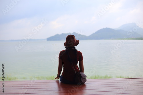 A woman sitting and enjoying the view of the river and mountain