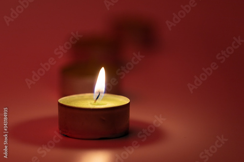 Burning candles on pink background with fire