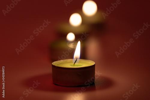 Burning candles on pink background with fire