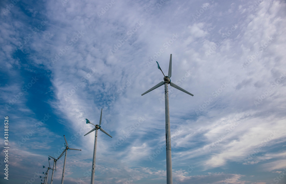 Windmills electricity and Bright blue sky with fluffy white clouds. Renewable energy. Sustainable electricity energy conservation concept. Windmills electricity and Bright blue sky with fluffy white clouds. Renewable energy. Sustainable electricity energy conservation concept.