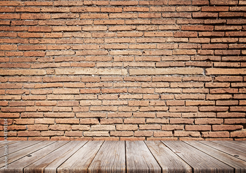 Wooden table in front of brick wall