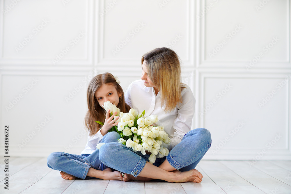 Portrait of little girl loving mother holding her and white tulips Portrait of little girl loving mother holding her and white tulips