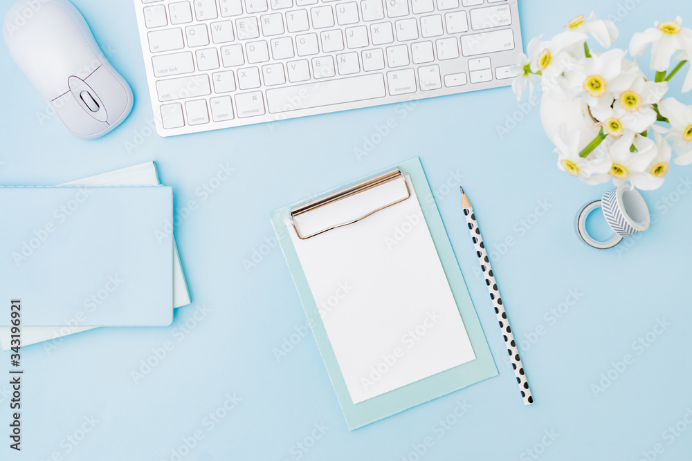 Flat lay blogger or freelancer workspace with a keyboard, flowers in a vase, office supplies on a color background Flat lay blogger or freelancer workspace with a keyboard, flowers in a vase, office supplies on a color background
