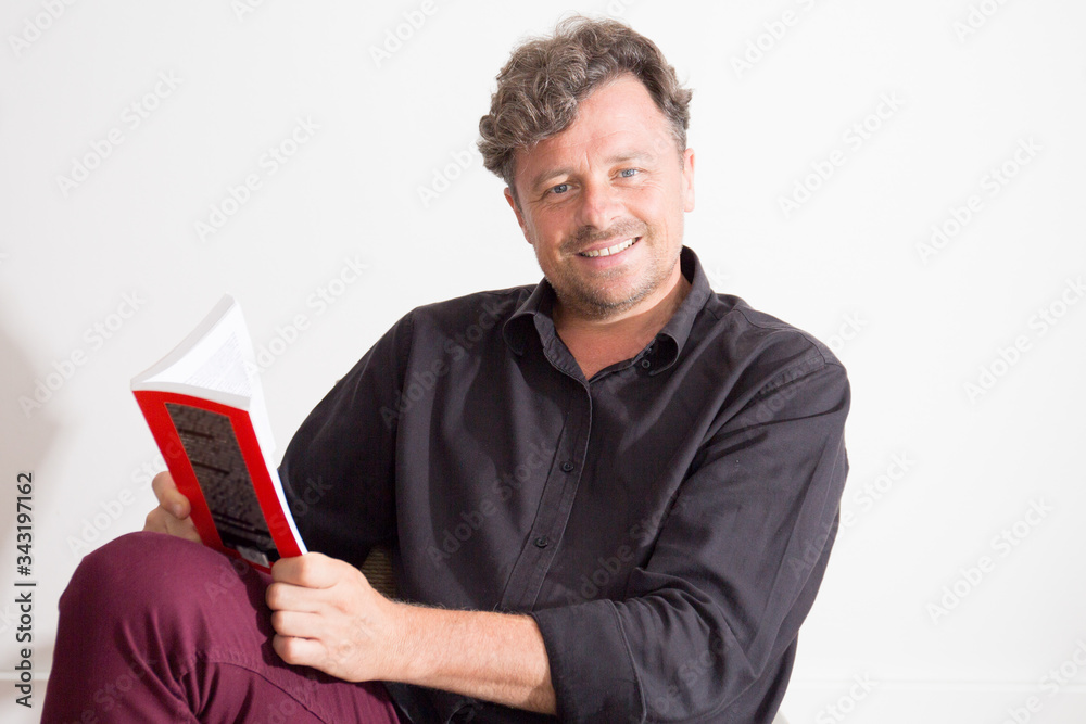 handsome man in 40s attractive reading book at home handsome man in 40s attractive reading book at home