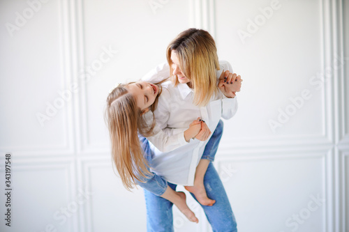 Portrait of little girl loving mother and holding her.