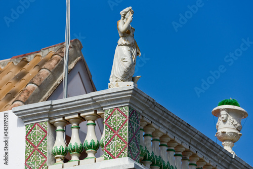 frieze of azulejos and statue on the facade of a house in Tavira, Algarve, Portugal