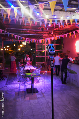 Vintage microphone on the stage of a night club. Beautiful multi-colored light
