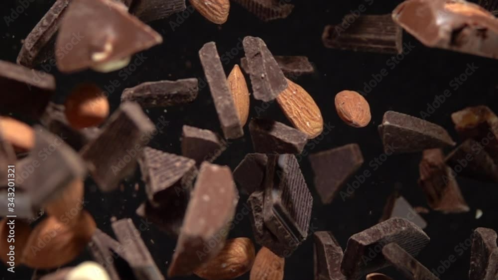 An explosion of pieces of dark chocolate with almonds on camera. Slow Motion 500fps An explosion of pieces of dark chocolate with almonds on camera. Slow Motion 500fps