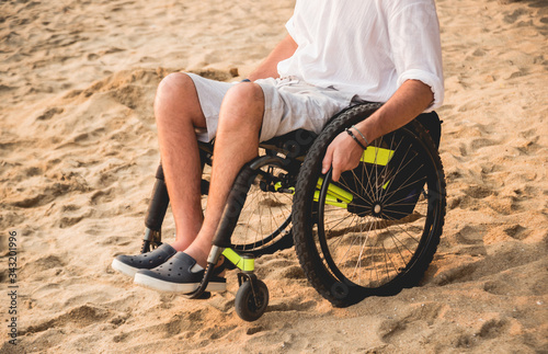 Disabled man in a wheelchair on the beach.