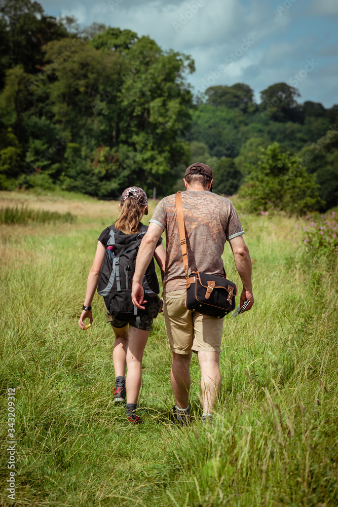 Father and daughter on a family hike through British countryside with bags