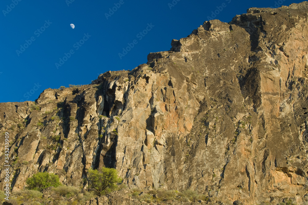 Moon over a cliff in the Roque Nublo Natural Monument. The Nublo Rural Park. Tejeda. Gran Canaria. Canary Islands. Spain.