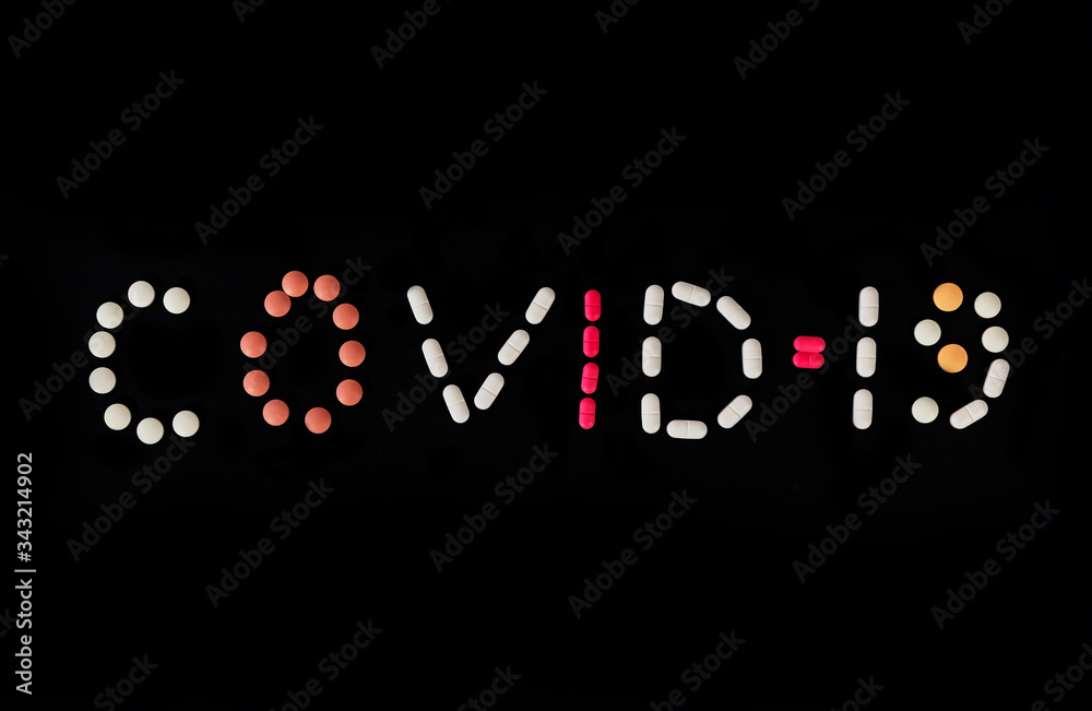 Word COVID-19 made from different medical pills on black background. Stop coronavirus. Many pills and tablets with space for text. Health care. Top view. Copy space. New image. Pharmaceutical pills