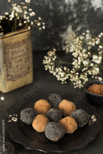 Prunes and dried apricots sweets with a sprinkling of poppy seeds, sesame and cocoa without sugar in vintage style. Organic and healthy food for snacking