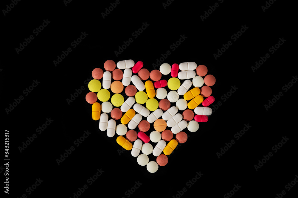 Many different pills and tablets folded in shape of heart on black background. Many pills and tablets with space for text. Health care. Top view. Copy space. New image. Pharmaceutical picture Many different pills and tablets folded in shape of heart on black background. Many pills and tablets with space for text. Health care. Top view. Copy space. New image. Pharmaceutical picture