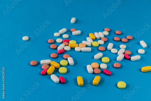 Different medicine pills, tablets on blue background. Many pills and tablets with space for text. Health care. Top view. Copy space. New image. Pharmaceutical picture. Closeup. Close-up. Soft focus