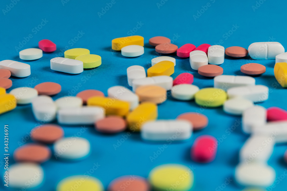 Different medicine pills, tablets on blue background. Many medicine pills and tablets with place for text. Health care. Top view. Copy space. New image. Pharmaceutical pills. Closeup. Soft focus. Different medicine pills, tablets on blue background. Many medicine pills and tablets with place for text. Health care. Top view. Copy space. New image. Pharmaceutical pills. Closeup. Soft focus.
