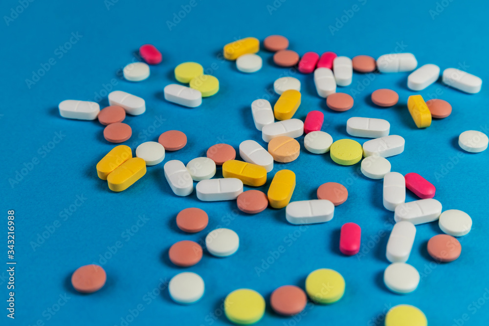Different medicine pills, tablets on blue background. Many medicine pills and tablets. Health care. Top view. Copy space. New image. Pharmaceutical pills. Closeup. Soft focus.