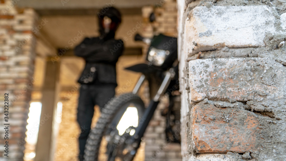 black off-road motorcycle behind a brick wall black off-road motorcycle behind a brick wall