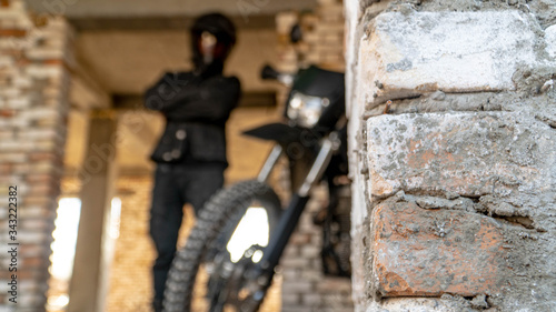 Fototapeta Naklejka Na Ścianę i Meble -  black off-road motorcycle behind a brick wall