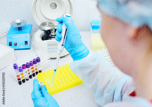 A scientist in a medical laboratory with a dispenser in his hands is doing an analysis