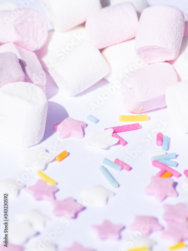 Sugar colorful sprinkles, stars and marshmallows, baking decorations in multicolor, bright picture, home made bakery, White background and heavy shade