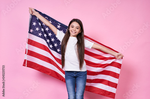 The American Dream. July 4, USA. beautiful girl in a white T-shirt with the American flag, on a pink background.