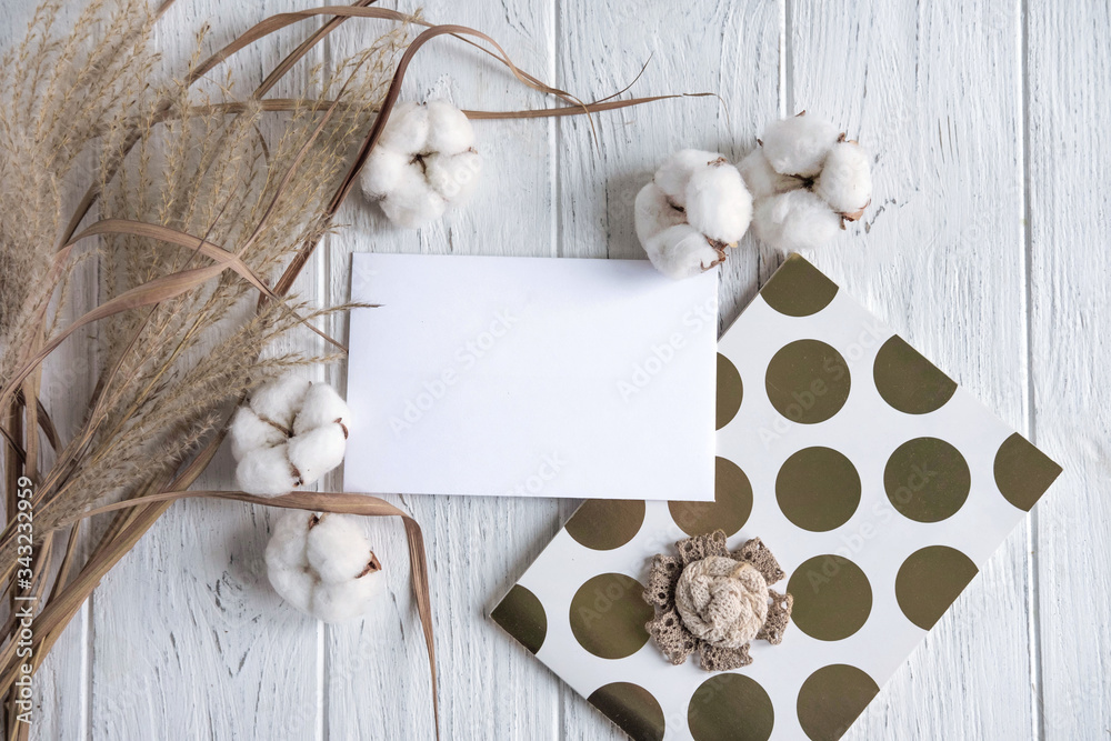 Mock up with cotton flowers and dried flowers on a light wooden background. Rustic frame for text with dried herbs and flowers. Winter background with flowers Mock up with cotton flowers and dried flowers on a light wooden background. Rustic frame for text with dried herbs and flowers. Winter background with flowers