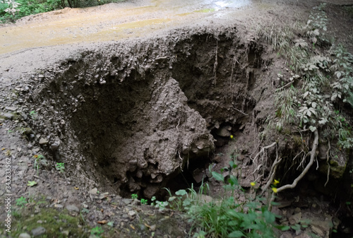 collapsed edge of the road from the rain. Akyduct for water runoff. photo