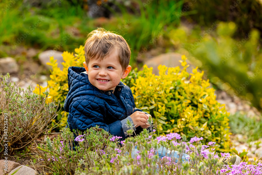 little todler playing with flowers in the garden