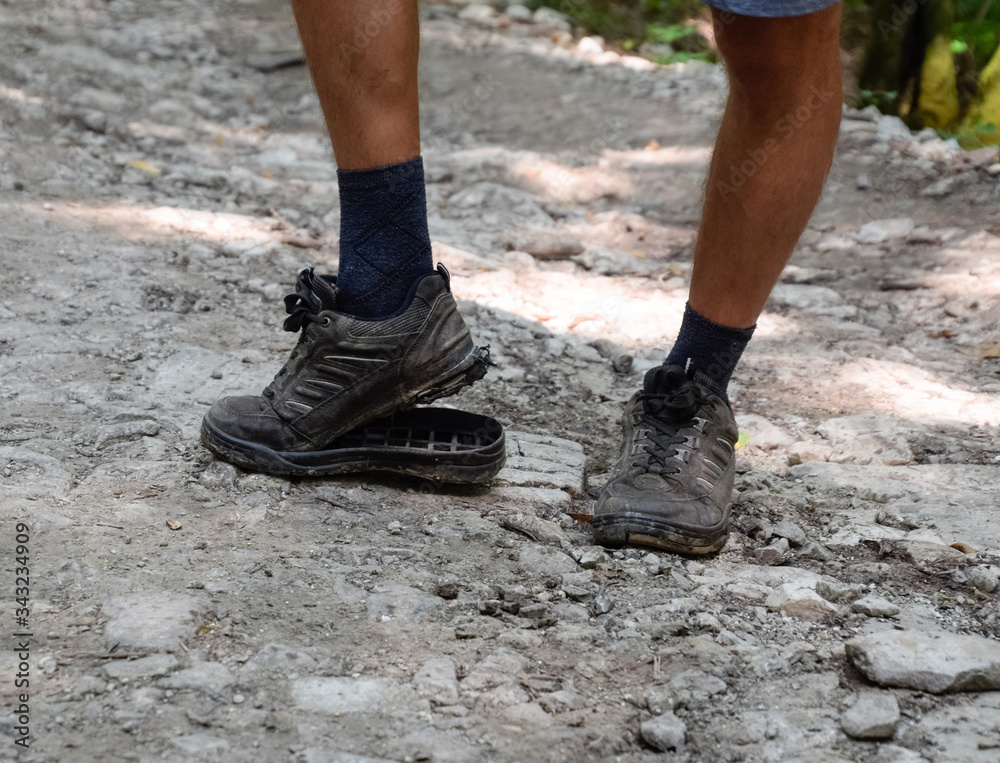 detached sole on the tourist's sneakers. They broke their boots in the woods. detached sole on the tourist's sneakers. They broke their boots in the woods.