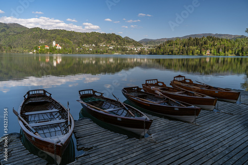 Fototapeta Naklejka Na Ścianę i Meble -  Bled, Sloveina, April 22, 2020: Lake shore with all the boats tied to the dock, due to coronavirus lockdown. Tourism in for trouble.